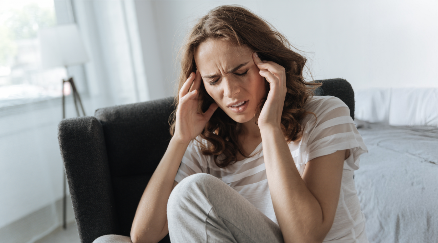 Frau hält sich schmerzhaft den Kopf